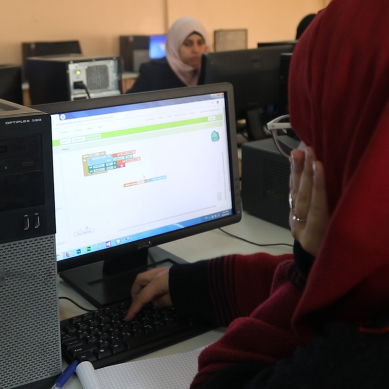 two girls work on app on their computer